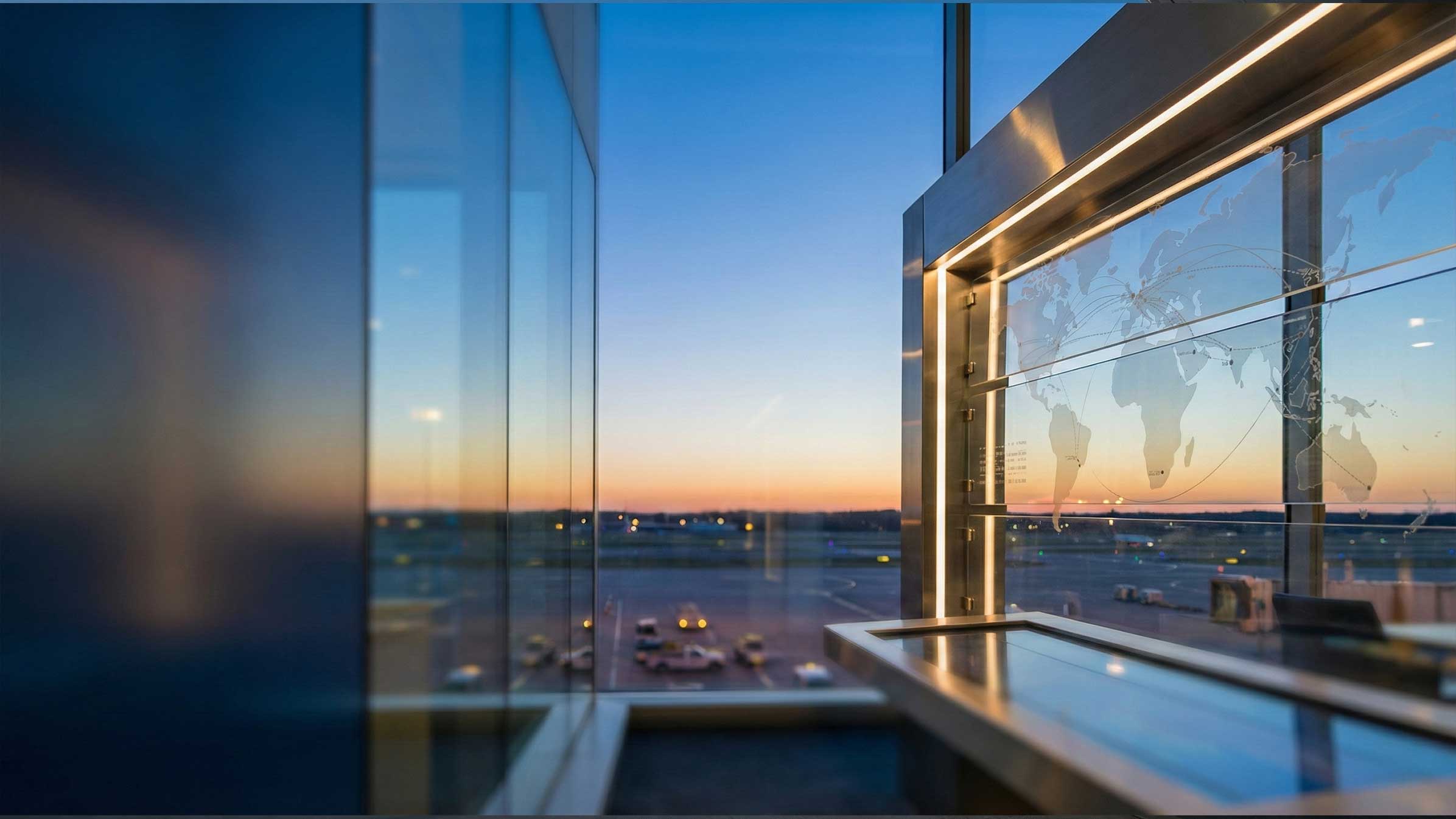 Airport terminal windows overlooking the apron at sunset.