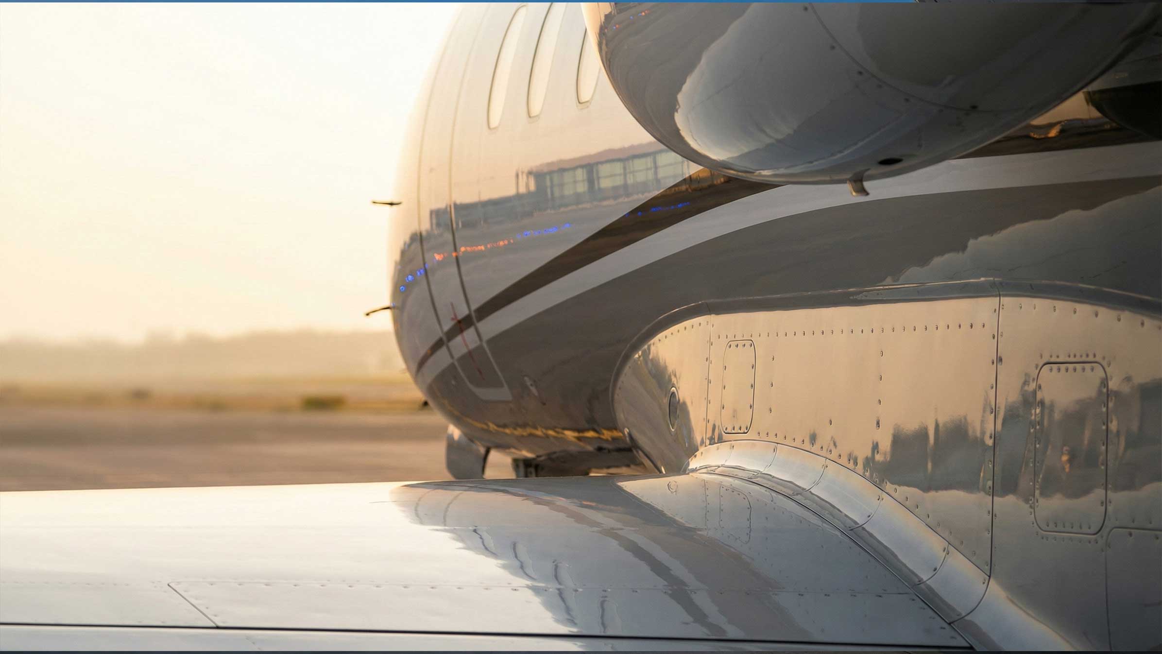 Sunlight reflected in the polished fuselage of a business aircraft.